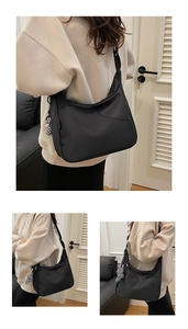 Détail d'un sac hobo en nylon noir avec un charm ours à damier dans un décor de maison