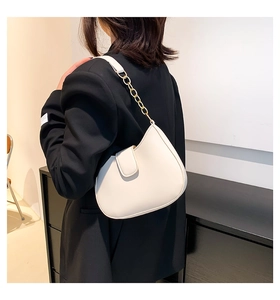 Gros plan du sac hobo blanc en cuir poli avec bandoulière à grosse chaîne dorée
