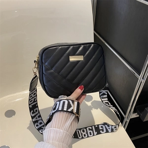 Chic black quilted crossbody bag with adjustable wide fabric strap and golden hardware