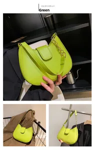 Vue détaillée d'un sac demi-lune vert vif avec chaîne dorée et texture lisse