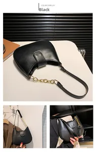 Vue détaillée du sac selle noir avec bandoulière à gros maillons dorés métalliques