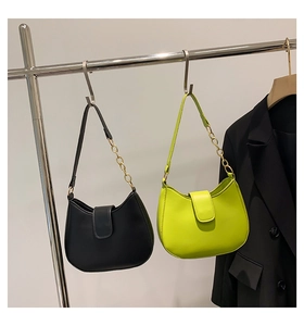 Détail des sacs de selle en cuir noir et vert citron avec chaînes dorées élégantes