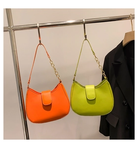 Détail des sacs demi-lune orange vif et turquoise avec bandoulières en chaîne dorée
