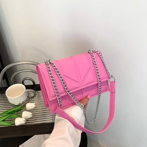Pink chain shoulder bag with geometric quilted texture in a modern lifestyle setting