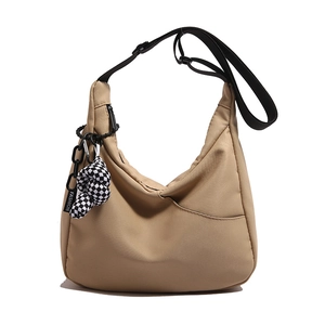 Sac bandoulière beige en forme de croissant avec sangle noire et breloque à carreaux