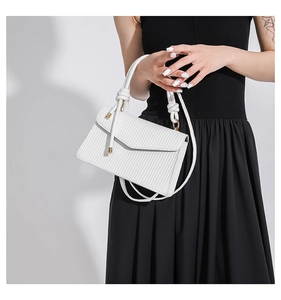 Close-up of white striped handbag showing woven texture and decorative knot detail