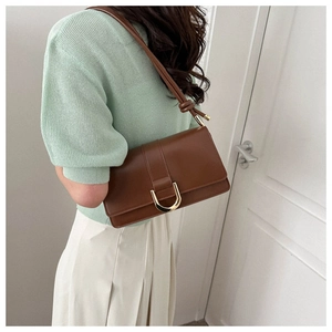 Close-up of brown PU leather shoulder bag with elegant gold U-shaped metal buckle