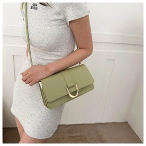 Side view of avocado green leather crossbody bag with golden horseshoe buckle details