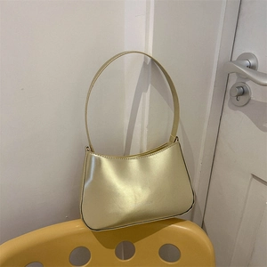 Minimalist glossy champagne gold underarm bag with simple crescent shape and shoulder strap
