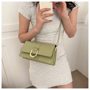 Detail view of avocado green crossbody bag with a gold semi-circle hardware buckle closure