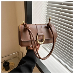 Detail of a brown PU leather square crossbody bag featuring a gold U-shaped metal buckle