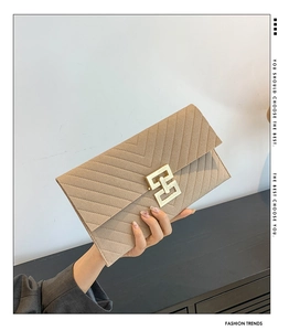 Detail der khakifarbenen Filz-Clutch mit Chevron-Steppung und goldener Schließe