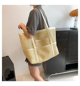 Modelo con bolso tote grande de malla beige con correas reforzadas para el verano