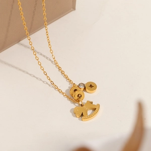 Detailaufnahme der goldenen Titan-Halskette mit Schaukelpferd und Zirkonia-Anhängern