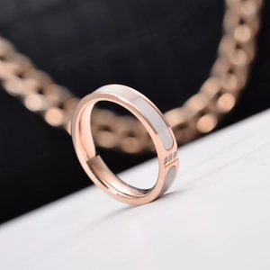 Detail of rose gold ring with white mother-of-pearl inlay and three small zircons
