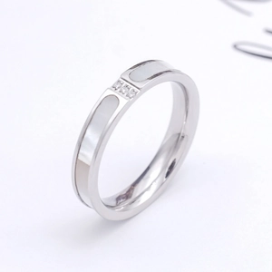 Detailed macro view of silver ring with white mother of pearl inlay and three tiny zircons