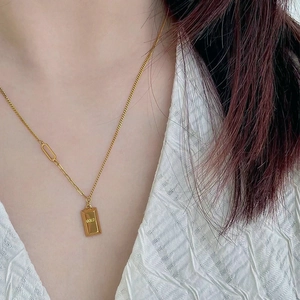 Detail of 18k gold plated bar necklace with GOLD engraving worn by a model