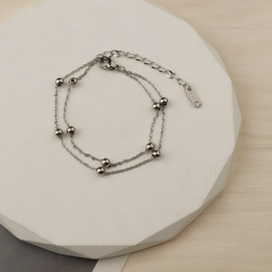 Minimalist silver double-layer beaded bracelet with K18D tag on a white display