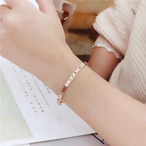 Rose gold Roman numeral bangle with crystals on female wrist for elegant daily wear