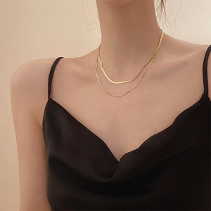 Collier double couche en maille serpent dorée sur mannequin pour un look élégant