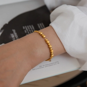 Minimalist gold titanium steel beaded bracelet with frosted matte finish for women