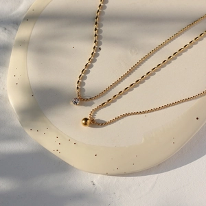 Doppellagige goldene Halskette mit klarem Zirkonia und einem massiven Goldkugel-Anhänger