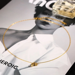 Goldene Lotus-Halskette mit zwei Anhängern auf einem modischen Zeitschriftenhintergrund