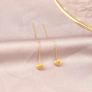 Elegant gold titanium heart drop earrings on soft purple silk fabric background