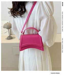 Vue détaillée du sac sablier fuchsia montrant la base incurvée et le cuir PU texturé