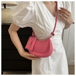 Detailed view of pink crescent underarm bag with matching small coin purse pendant