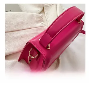 Gros plan du sac à main rose fuchsia avec ferrures dorées et coutures de précision