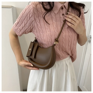 Detail of dark brown saddle bag with a mini square pouch and stylish shoulder strap