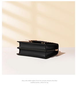 Zijaanzicht van zwarte crossbodytas met drielaagse accordeonstructuur en gouden hardware-accent