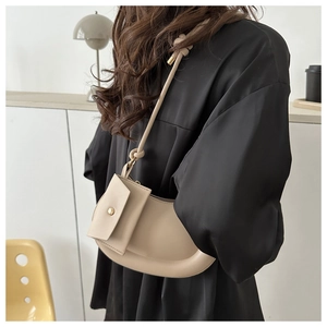 Detail of a creamy beige crescent underarm bag with a mini pouch and knot strap