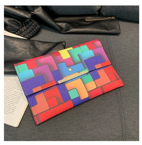 Detail der bunten geometrischen Umschlagtasche mit goldenem Magnetverschluss aus Metall