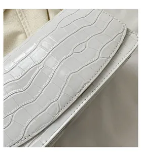 Detailed close-up of white crocodile pattern texture on stylish PU leather flap bag