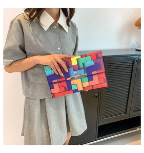 Detail der bunten geometrischen Clutch mit goldener Metallschnalle von Model gehalten