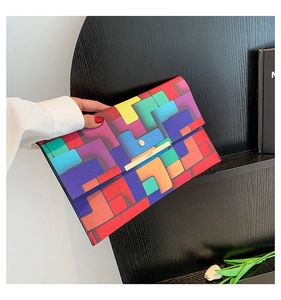 Detail der bunten geometrischen Clutch mit goldenem Metallverschluss und Ledertextur