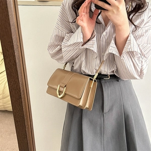 Brown vintage square crossbody bag with gold U-buckle shown in a mirror selfie styling
