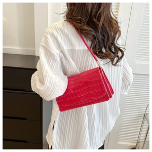 Shoulder bag in red crocodile pattern with glossy finish and gold hardware details
