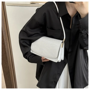 Detail of white crocodile pattern square bag with premium metallic hardware and leather texture