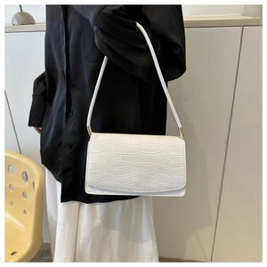 Detail of white crocodile pattern shoulder bag with elegant golden metal buckles