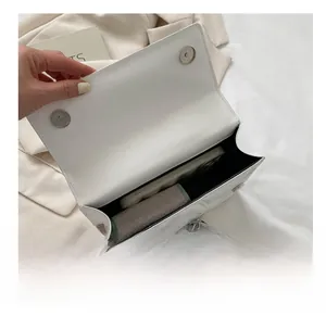 Internal view of white quilted shoulder bag showing phone and wallet storage capacity
