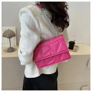 Detailed view of rose pink crossbody bag with geometric quilting and silver chain strap