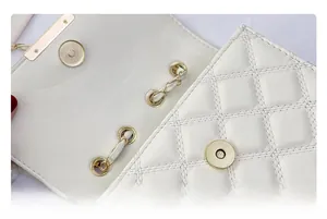 Détail du sac en cuir matelassé crème avec boucle magnétique dorée et chaîne tressée
