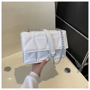 Detail of white PU leather crossbody bag with 3D geometric quilted texture and silver chain