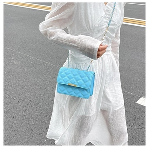 Détail du petit sac matelassé bleu ciel avec chaîne dorée et décoration de perle
