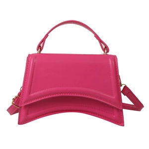 Sac à main minimaliste fuchsia avec base sablier et détails dorés sur fond blanc