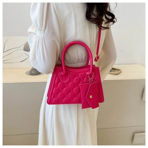Detail of rose red quilted crossbody bag with matching mini envelope pouch and round handle