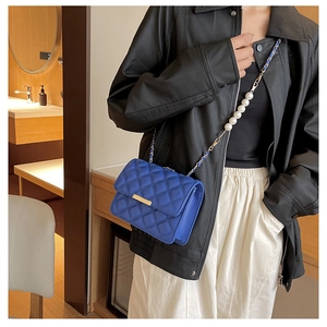 Détail du sac bandoulière matelassé bleu roi avec élégante chaîne en perles et dorée